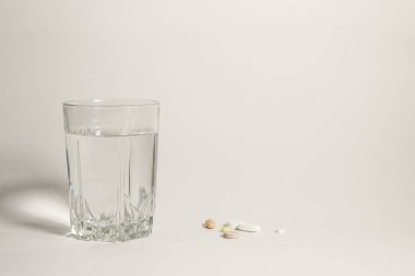 dolu bardak su ve bir avuç hap beyaz arka plan üzerinde