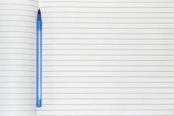 用干净的白色床单放在记事本上的笔记本上的蓝色笔 — 图库照片