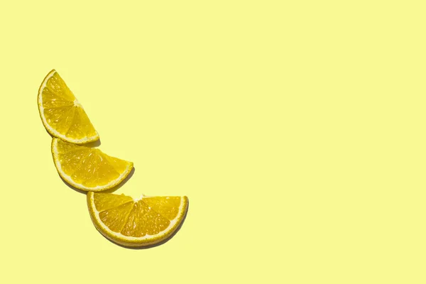 üç parlak portakal dilimleri birbirine soldaki metin için doğru yere sarı bir arka plan üzerinde yalan