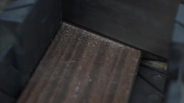 Gros plan homme en gants blancs sciage bureau en bois avec une scie 