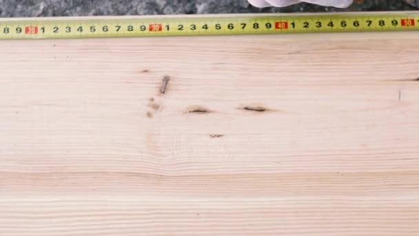 近距离的木匠测量木制的桌子与黄色的磁带措施在车间 白手套的人 — 图库视频影像