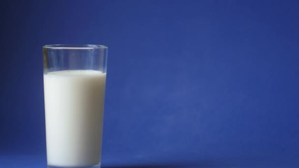 Hand Pick Glas Melk Klassieke Blauwe Achtergrond Begrepen Ruimte Video — Stockvideo