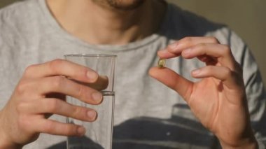 Adam tablet yutar ve bardak içer. Beslenme takviyesi. Sağlık hizmetleri kavramı 