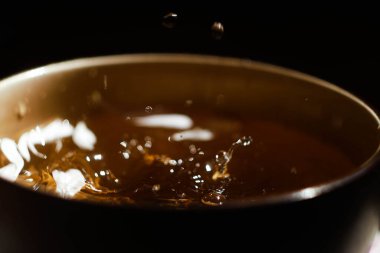 Kaseye çiçek yapraklarıyla su sıçrıyor. Tayland töreni. Budizm yemek kasesi