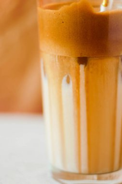 Kağıt kamışlı Dalgona kahvesi. Kağıt arkaplanda moda içki. Soğuk kokteyl. Kremalı kahve.