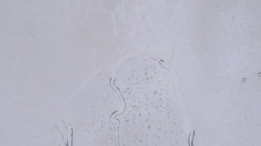 Camdan aşağı su akıyor. Soyut dalgalar. Fırtınalı yağmur havası. Aqua sakin rengi. 