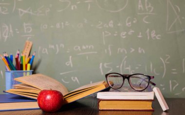 Kırtasiye ve kitaplar masanın üzerinde yatıyordu. Çalışma süreci. Öğretmenin masası. Okula dönelim. Uzayı kopyala Pankart okunuyor