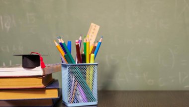 Kırtasiye ve kitaplar masanın üzerinde yatıyordu. Çalışma süreci. Öğretmenin masası. Okula dönelim. Uzayı kopyala Pankart okunuyor