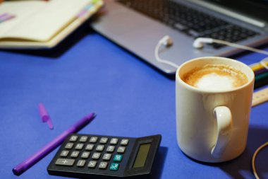 Öğrenci masası. İşletme. Ofis işi konsepti. Klasik mavi arka plan. Evrak işleri. Bir fincan kahve. Not defteri ve sabit.