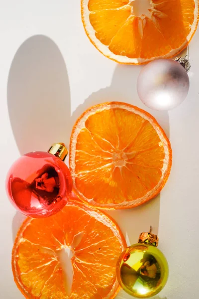 Suszone Plastry Pomarańczy Kulkami Świątecznymi Białe Tło Kartka Życzeniami Noworocznymi — Zdjęcie stockowe