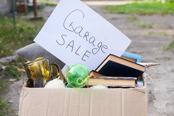 Garaj satışı tabelası. Eski eşyalar kutuda. Eski eşyaları satıyorum. Antika pazarı. İkinci el..