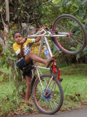 Çocuğa yol kenarında sol bacağını tarafından demirlemiş ve holding ise bir bisiklet kolu ön yüksek yerden ise sağ ayak üzerinde sağ pedal yaparken asansörleri