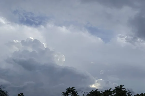 Rain clouds with bright area of sunlight escaping from beneath the thickness of the clouds