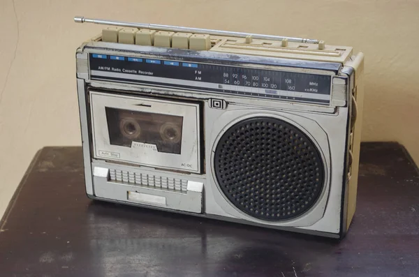 里面在板材表面坐一个老黑色和银色 收音机盒式磁带录音机 顶部是一个可扩展的天线 — 图库照片