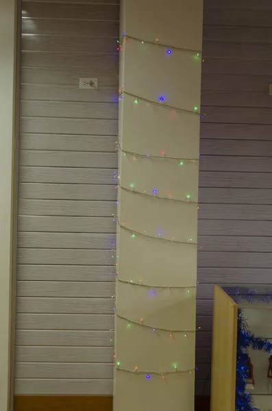 Rows of small decorative lights across along the height of a column inside.