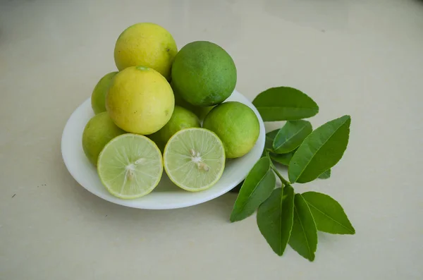 Uma Placa Branca Amarelo Maduro Verde Imaturo Chave Limas Dos — Fotografia de Stock