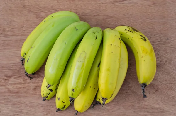 Fundo Placa Dobra Marrom Uma Mão Amarelo Maduro Verde Bananas — Fotografia de Stock