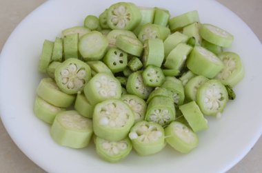 Pişirmeye hazırlanmak için küçük parçalar halinde kesilmiş beyaz bir tabak..