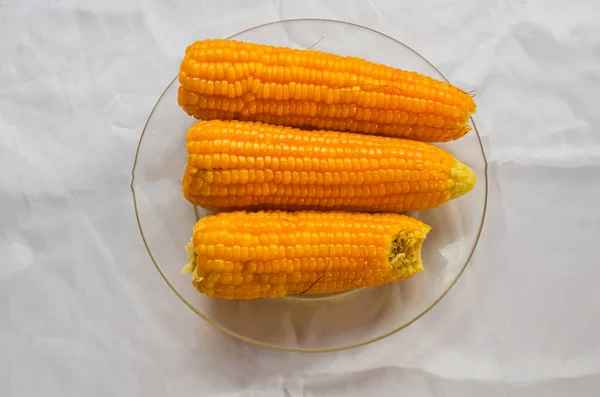 Corns that was freshly plucked from their tries were boiled and placed in a transparent plate on top of white cloth background