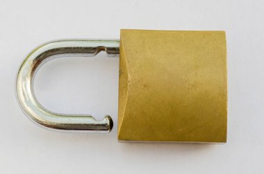 Beyaz bir arka planda prangası açık duran çelik bir asma kilit..