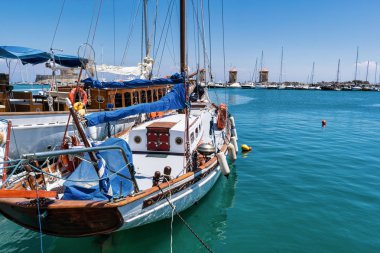 Rodos Eski Liman kadar yelken tekne palamarla. Uzaktan üç ünlü yel değirmenleri görebilirsiniz