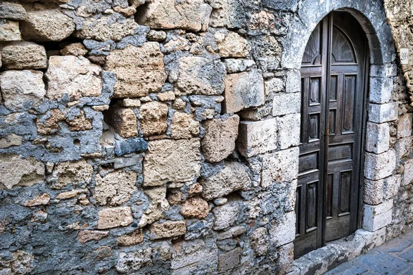 Picture of a wood door on the entrance to a old rustic stone house.