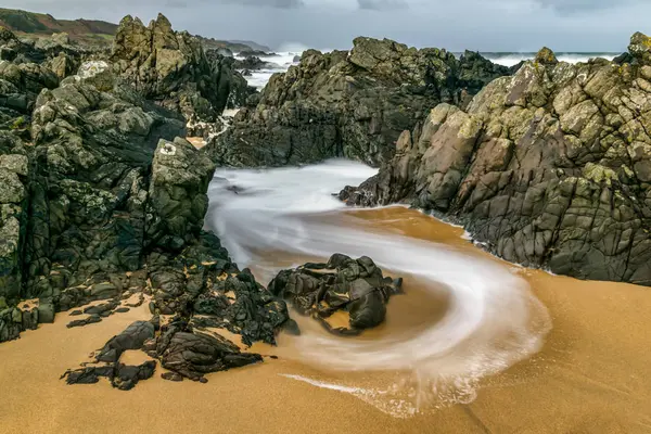 Yavaş çekim hızı yine de plajda kayalar dönen bir dalga bu görüntüsünü yakalamak için kullanıldı. Eğriler beyaz köpük oluşturulan basık su