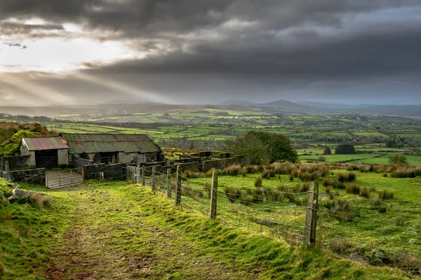 Ireland countryside with the suns rays coming in from the clouds