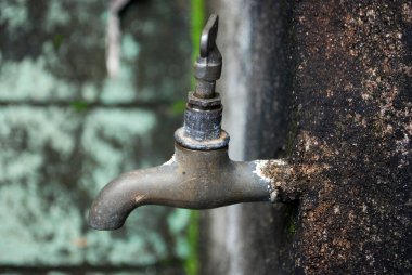 Eski musluk paslı bir metal boruya bağlanıyor. Eski model musluk, kapalı musluk.