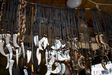 Siyah bir ip üzerine oyulmuş kemik tılsımları