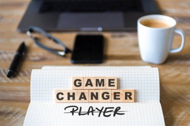 Closeup dizüstü ahşap masa arka plan üzerinde odaklanmak ahşap bloklar üzerinde oyun değiştirici değil oyuncu yapma harflerle metin. Kavram görüntü. Dizüstü bilgisayar, Gözlük, kalem ve cep telefonu ufuk arka planda