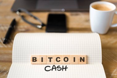 Closeup dizüstü vintage Resepsiyon yüzeyi üzerinde ön odak ahşap bloklar Bitcoin nakit metin yapma harflerle. İşletme kavramı resmi office araçları ve kahve fincanı arka planda