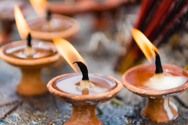 Terra-cota kandil Nepal tapınağında dini teklifleri olarak. İpek bulanık arka plan üzerinde sopa.