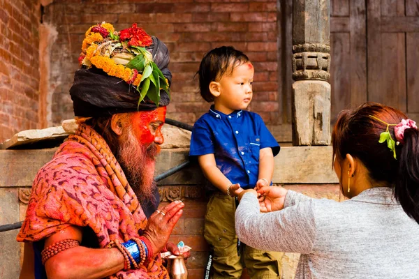 帕斯帕提那 尼泊尔 2018年7月17日 圣洁萨杜人以传统被绘的面孔和唯一衣裳是祝福孩子在帕斯帕提那 一个著名和神圣的印度教寺庙复合体在尼泊尔 — 图库照片