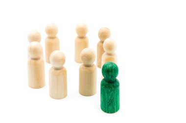 Ahşap figürler, beyaz arka plan üzerinde izole çemberi önünde kalabalıktan ayakta yeşil şekil. Liderlik kavramı