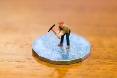 Ahşap arka plan üzerinde izole para, sikke, manuel çalışma kazma madenci olarak minyatür resim