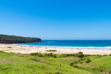 Çakıllı plaj, Nsw, Avustralya-Ocak 4, 2019: insanlar, çakıllı plaj güneşli havanın tadını harika sörf plaj ve bush ile popüler bir kamp alanı Murramarang Milli Parkı içinde yürür.