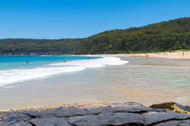 Çakıllı plaj, Nsw, Avustralya-Ocak 4, 2019: insanlar, çakıllı plaj güneşli havanın tadını harika sörf plaj ve bush ile popüler bir kamp alanı Murramarang Milli Parkı içinde yürür.