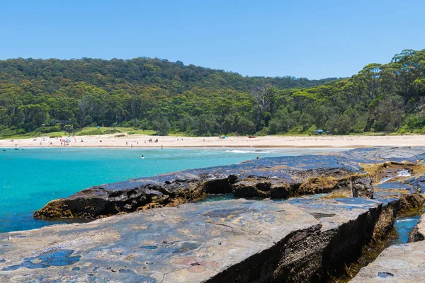 Çakıllı plaj, Nsw, Avustralya-Ocak 4, 2019: insanlar, çakıllı plaj güneşli havanın tadını harika sörf plaj ve bush ile popüler bir kamp alanı Murramarang Milli Parkı içinde yürür.