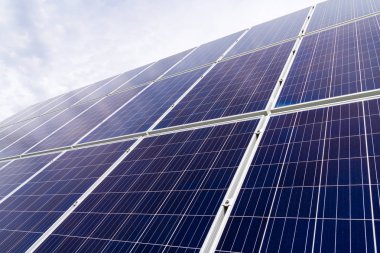 Arka planda mavi bulutlu gökyüzü ile enerji üretim tesisi güneş hücresi fotovoltaik paneller