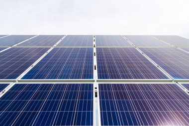 Arka planda mavi bulutlu gökyüzü ile enerji üretim tesisi güneş hücresi fotovoltaik paneller