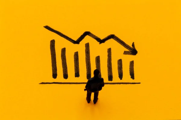 Miniature Figurine Posed Businessman Front Descending Graph Negative Performance Concept Stock Photo