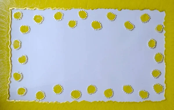 Yellow frame on a white background with specks around the edges of the frame, painted with acrylic paints on glass in the technique of dotted mural