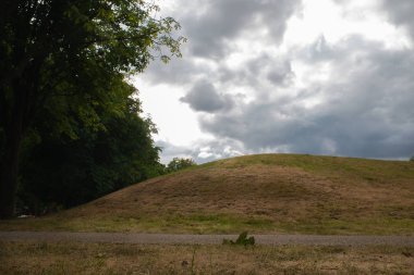 Ağaçlar hill ve mavi gökyüzü bulutlu arka plan ile ön planda yaya yürüyüş ile