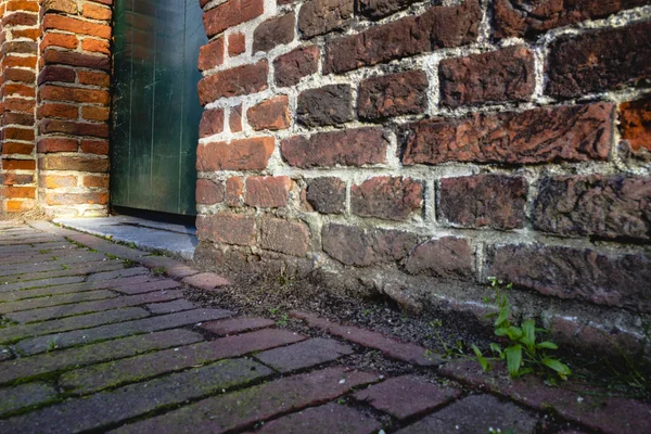 Kırmızı tuğla duvar ve yeşil kapı