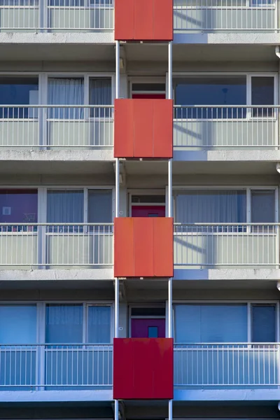 Image of a modern building with red details on the balconies