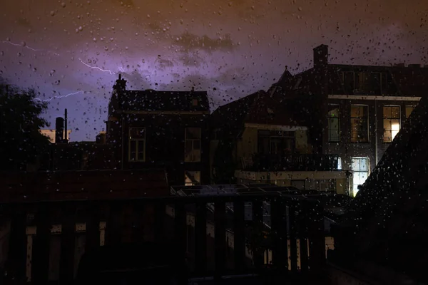 窓ガラスに雨の滴、窓の雨が街のライトをぼやけた, — ストック写真