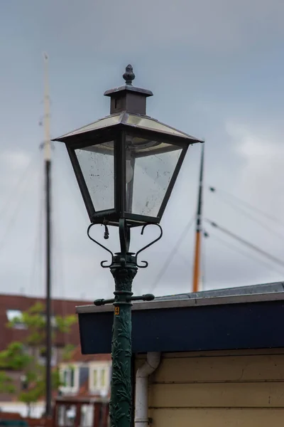 Street lamppost with the wooden masts in the background — Stock Photo, Image