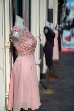 Mağaza penceresi önünde renkli elbiseler mankenler