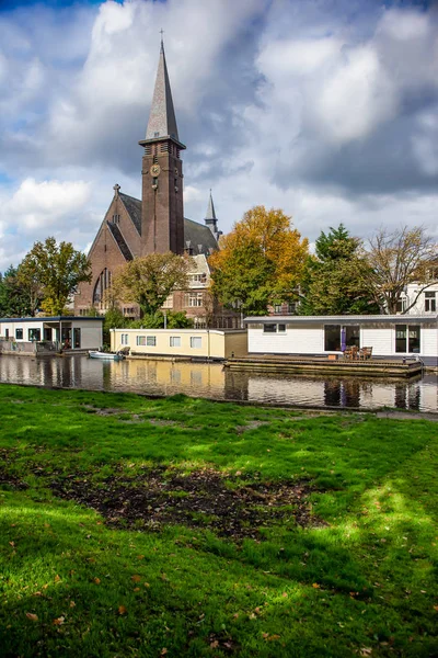 オランダ・ライデン運河における教会と屋形船 — ストック写真